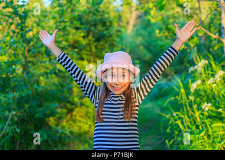 Une jolie petite fille heureuse dans la forêt sur une journée ensoleillée Banque D'Images