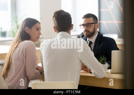 Le courtier à l'écoute de clients au cours de la réunion de bureau ou programm Banque D'Images
