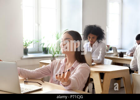 Heureux travailleur féminin méditer en position du lotus sur le lieu de travail Banque D'Images