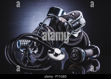 Vue rapprochée d'haltères différentes et stéthoscope, concept de vie sain Banque D'Images