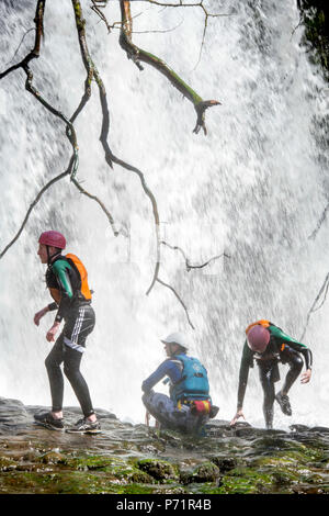 Un instructeur supervise un groupe de marche de l'aventure gorge avec le pays de Galles sur la rivière près de Mellte Pontneddfechan dans les Brecon Beacons UK Banque D'Images