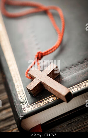 Gros plan du collier croix chrétienne en bois simple sur la sainte Bible Banque D'Images