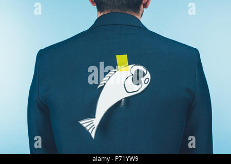 Vue arrière de l'homme d'affaires en costume avec du papier fait à l'arrière du poisson, April Fools Day concept Banque D'Images