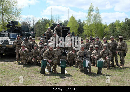 Les soldats du groupement tactique Pologne posent avec quatre cratères frais utilisés pendant la formation de démolition de tir réel près de Bemowo Piskie Domaine de formation, la Pologne, le 10 mai. L'interopérabilité formation a aidé les États-Unis et le Royaume-Uni l'ingénierie groupe de combat des soldats effectuent des missions de démolition dans un environnement mixte. Banque D'Images