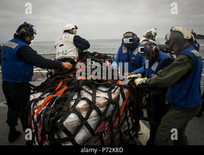 Océan Pacifique - Marines à combattre, le 15 bataillon de logistique Logistique Élément de combat de la 15e Marine Expeditionary Unit, affectés à la lutte contre les marins et du fret avec le service du pont, USS Pearl Harbor (LSD 52) enlever les sangles des rations alimentaires livrés au navire de ravitaillement vertical une mission au cours de l'exercice, l'unité de formation mixte le 11 mai 2017. La capacité de ravitaillement en mer donne le 15e MEU et l'Amérique latine le Groupe amphibie de la mobilité et la durabilité nécessaires pour maintenir un avantage sur les adversaires asymétriques. Au cours de la 15e, COMPTUEX MEU et AMAARG s'exer Banque D'Images