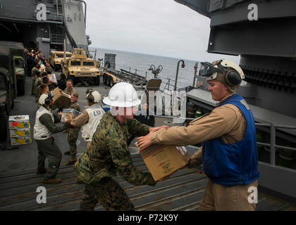 Océan Pacifique - Marines et les marins à bord de l'USS Pearl Harbor (LSD 52) col fournitures livrées au navire de ravitaillement vertical d'une mission au cours de l'exercice, l'unité de formation Composite 11 Mai, 2017. La capacité de ravitaillement en mer donne à la 15e unité expéditionnaire de marines et de l'Amérique latine le Groupe amphibie de la mobilité et la durabilité nécessaires pour maintenir un avantage sur les adversaires asymétriques. Au cours de la 15e, COMPTUEX MEU et AMAARG exerce un large éventail de capacités de réponse aux catastrophes et les opérations de sécurité maritime pour le contrôle maritime et complexe de guerre. Banque D'Images