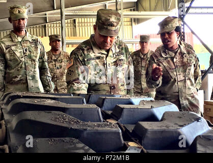 L'Adjudant-chef 2 Kyona Hendricks (à droite), responsable de l'activité de prise en charge d'officier, 64e Bataillon de soutien de la Brigade Blindée, 3e Brigade Combat Team, 4e Division d'infanterie, explique comment l'ASS est le traitement d'une chenille de char pour la livraison comme le général Ryan F. Gonsalves (centre), général commandant la 4e, Inf. Div. et de Fort Carson, et commande la Division Sgt. Le major Michael A. Crosby (à gauche) visiter le site général de la brigade à Grafenwoehr Domaine de formation, l'Allemagne, le 11 mai 2017. Gonsalves a également livré du Commandement des forces de l'armée américaine Prix d'excellence de l'offre de deuxième place catégorie SSA tro Banque D'Images