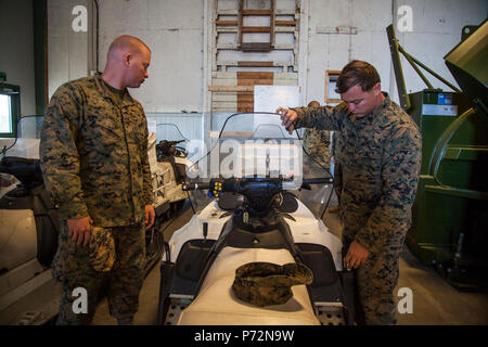 Le sergent des Marines des États-Unis. Jared Lingle, gauche, un assaut Véhicule amphibie (AAV) d'équipage, et le Sgt. Carlos Diaz, un technicien d'AAV, avec le Siège et support compagnie, 4e Bataillon d'AAV, 4e Division de marines, regardez une motoneige lors d'une tournée d'un bataillon de soutien du pays hôte dans le hangar d'équipement Vaernes, la Norvège, le 11 mai 2017. Le soutien de la nation hôte bataillon est l'élément de l'Armée norvégienne de la Marine Corps place préalable (Norvège programme MCPP-N). MCPP-N est de l'avant pour réduire les prépositionnées temps de réponse. Banque D'Images