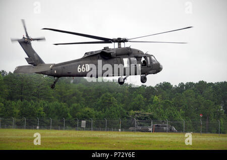 Un UH-60A Black Hawk de l'équipage de l'hélicoptère en vol stationnaire près de Lowe pratiques, de l'héliport de l'Armée de Fort Rucker, en Alabama, le 8 juillet 2013 au cours de l'US Army Aviation rotatif du programme de formation. Formation pour devenir pilote d'hélicoptères Black Hawk nécessite plus d'une année d'enseignement à Fort Rucker. Banque D'Images