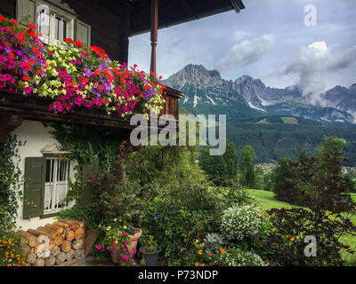 Balcon en bois plein de fleurs d'été avec Wilder Kaiser en arrière-plan Banque D'Images