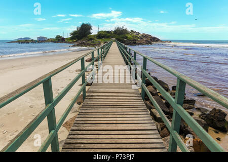 Florianopolis, Santa Catarina, Brésil. Jetée en bois sur la plage de sable avec vue sur la mer et l'île en arrière-plan aux beaux jours d'été. Banque D'Images