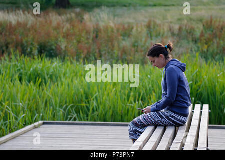 Femme était assise sur un banc à Hilbert & Grosvenor Park Banque D'Images