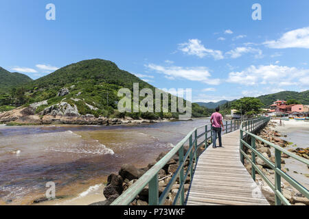 Florianopolis, Santa Catarina, Brésil. Un touriste man walking sur une jetée en bois à côté de la mer aux beaux jours. Banque D'Images