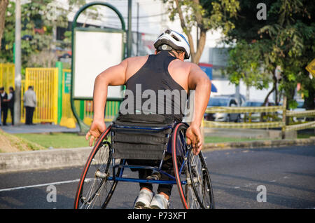 Un athlète en fauteuil roulant pendant la compétition de course dans la rue Banque D'Images