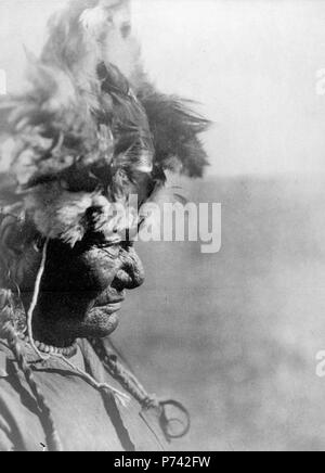 Anglais : coiffure homme Médecine des Pieds-Noirs en 1928. À partir de 'The North American Indian" par Edward S. Curtis. English : coiffure d'un sorcier-guérisseur pied-noir en 1928 . 19281 Blackfoot Medicine Coiffure Banque D'Images