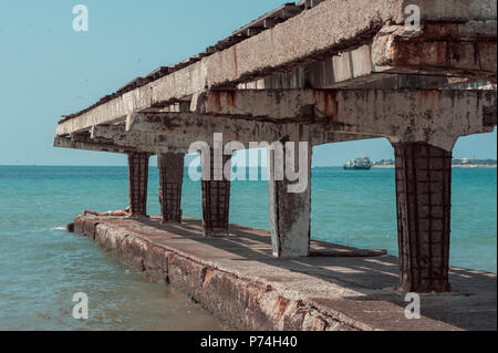 Vieux fer rouillé, bollards d'amarrage montés sur un pilier de béton à l'arrière-plan. Banque D'Images