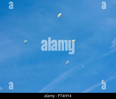 Parapentes colorés à l'étendue de ciel bleu Banque D'Images