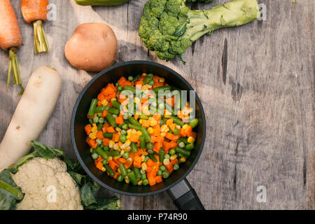 Légumes Pommes de terre, carottes, choux-fleurs, brocolis en pot sur table en bois Banque D'Images