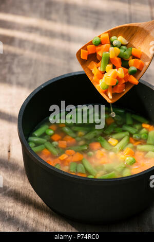 Ragoût aux légumes en pot gris sur la couleur de la serviette sur fond de bois Banque D'Images