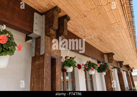 Libre de poutre en bois et la jonction pilier lien professionnel par plaque de vis métalliques. La structure de support de toit extérieur et pots de géranium pendaison Banque D'Images