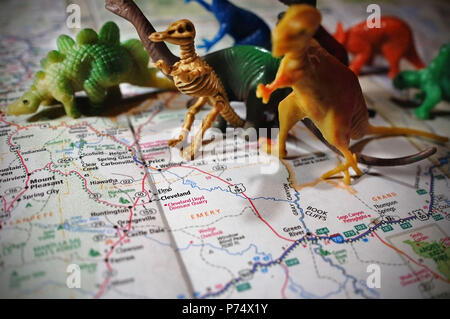 Dinosaures jouets en photo avec une carte de l'Elmo, Utah et le Cleveland Lloyd Dinosaur Quarry. Banque D'Images