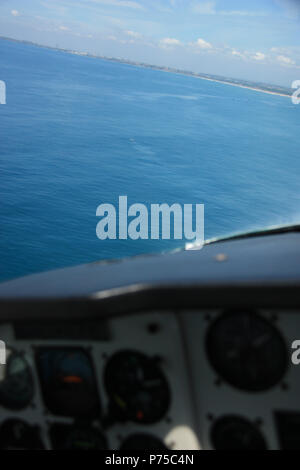 Les bateaux de pêche et une baleine à bosse au large de la côte du Ghana, vu depuis le cockpit d'un avion Banque D'Images