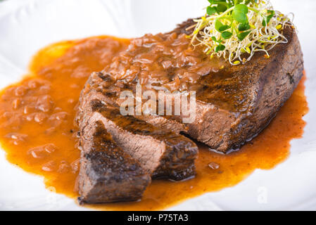 Bien-fait le boeuf mariné grillé bifteck avec la sauce sur la plaque Banque D'Images