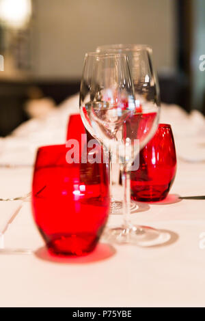 Restaurant Table en verre avec décoration rouge Arrière-plan flou Banque D'Images