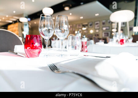 Rouge et Blanc lumineux Restaurant Table verres à l'arrière-plan flou Banque D'Images