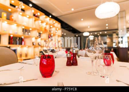 Restaurant Table en verre avec décoration rouge Arrière-plan flou Banque D'Images