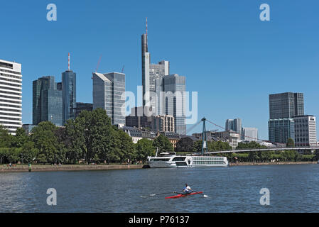 La rameuse en rouge bateau sur la rivière principale en face de la skyline, Francfort, Allemagne Banque D'Images