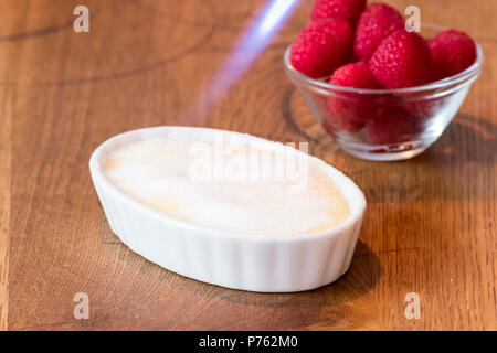 Crème catalane sur table en bois en blanc bol à fruits rouge Banque D'Images