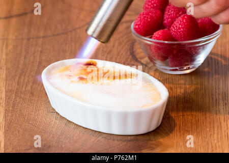 Crème catalane sur table en bois en blanc bol à fruits rouge Banque D'Images
