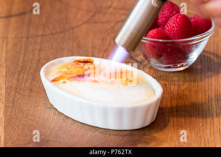 Crème catalane sur table en bois en blanc bol à fruits rouge Banque D'Images