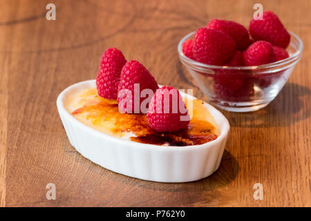 Crème catalane sur table en bois en blanc bol à fruits rouge Banque D'Images
