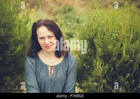 Souriante jeune femme européenne adultes dans le jardin. Portrait en extérieur aux tons Vintage Banque D'Images