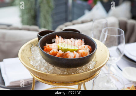 Crevettes à la lime dans un bol en fonte dans la glace sur une table dans un restaurant. Banque D'Images