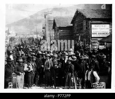 . Anglais : foule de personnes en attente d'un mail à Dawson, bureau de poste, montrant les constructions en bois rond et signer pour le bureau du courtier, ca. 1898 . Anglais : Légende sur l'image : en attente de mail à Dawson City Bureau de poste. Photo par F.H. Nowell, 1985 sujets (LCTGM) : bureaux de poste--Territoire du Yukon--Dawson ; la foule--Territoire du Yukon--Dawson ; rues--Territoire du Yukon--Sujets Dawson (LCSH) : immeubles de bureaux de poste--Territoire du Yukon--Dawson . vers 1898 3 Nombre de personnes en attente d'un mail à Dawson, bureau de poste, montrant les constructions en bois rond et signer pour le bureau du courtier, ca 1898 NOWELL (30) Banque D'Images