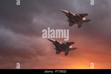 US Air Force McDonnell Douglas, deux à basse altitude de l'USAF F-15E Strike Eagles au coucher du soleil. Vol à basse altitude à grande vitesse en avion de chasse, avec un beau brillant orange Banque D'Images