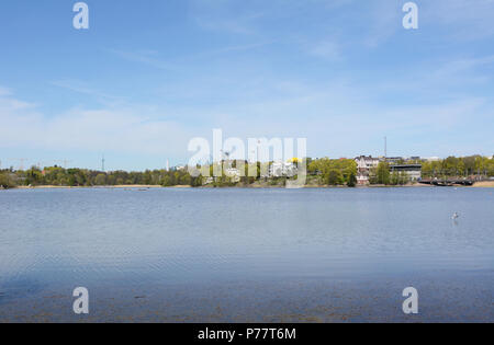 Toolo Bay dans la région de City Park, Helsinki, Finlande. À travers l'eau, des manèges à Linnamaki amusement park peut être vu au-dessus des arbres. Banque D'Images