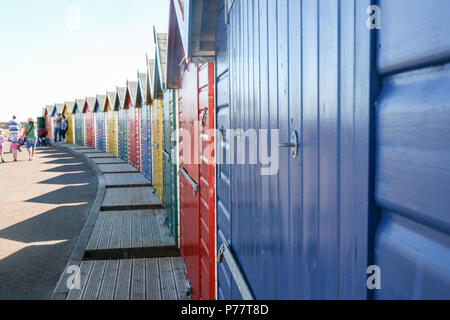 Balades en famille peintes de couleurs vives des cabines de plage à Dawlish Warren sur une journée ensoleillée à proximité de la plage, Devon, Angleterre, Europe. Banque D'Images