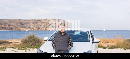 Handsome man standing in front of white location Banque D'Images