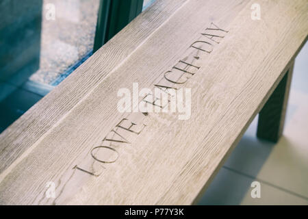 Assise en bois avec les mots l'amour chaque jour sculpté dans elle à Daylesford Organic farm shop. Daylesford, Cotswolds, Gloucestershire, Angleterre Banque D'Images