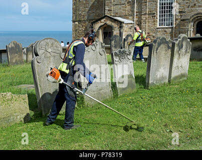Jardiniers strimming, St Mary's Church, Whitby, North Yorkshire, England UK Banque D'Images