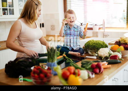 Maman enceinte et l'enfant la préparation de repas Banque D'Images