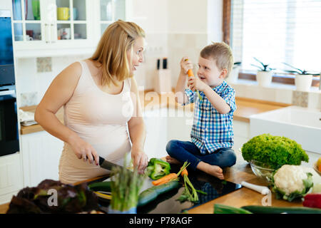 Maman enceinte et l'enfant la préparation de repas Banque D'Images