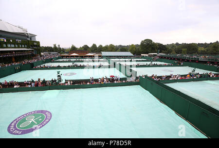 Une vue générale de caches sur les courts annexes que la pluie cesse de jouer sur la troisième journée du tournoi de Wimbledon à l'All England Lawn Tennis et croquet Club, Wimbledon. Banque D'Images