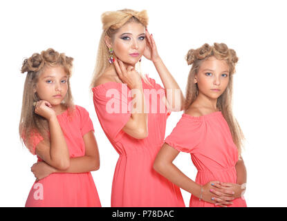 Mère de deux adorables jumelles dans de belles robes rose Banque D'Images