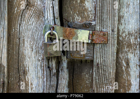 Cadenas fermé sur une ancienne porte de protection boisée. Banque D'Images