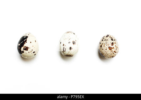 Trois oeufs de cailles dans une rangée sur un fond blanc. Vue de dessus, télévision Banque D'Images